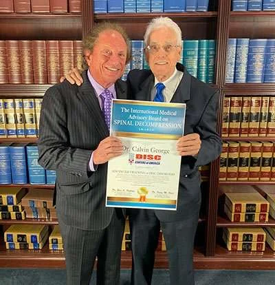 Dr. Calvin George receiving his National Non-Surgical Spinal Decompression certification from Dr. Eric Kaplan